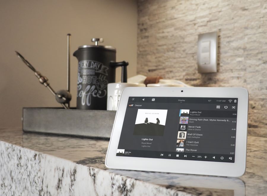 A Control4 touchscreen displaying music selections from Deezer.